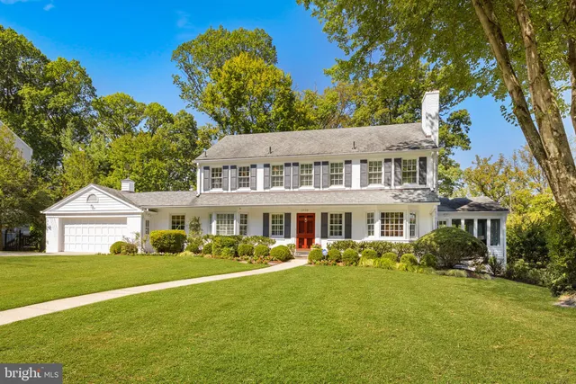 a front view of a house with a garden and trees