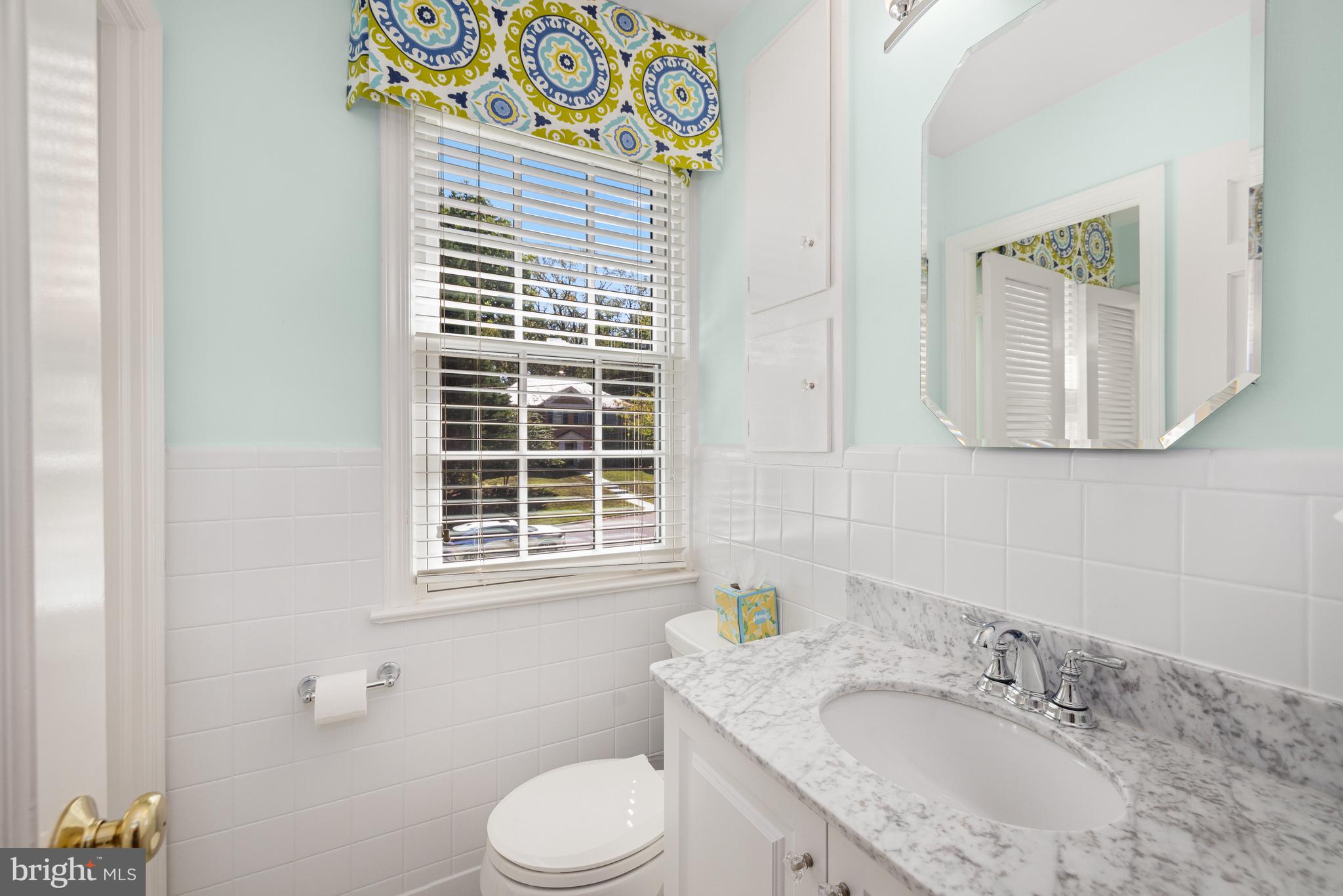 3730 Cardiff Road Chevy Chase, MD 20815 - Photo 29 of 49 a bathroom with a granite countertop toilet a sink a mirror and a window