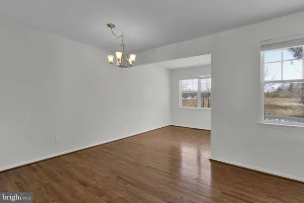 a view of wooden floor chandelier and windows in a room