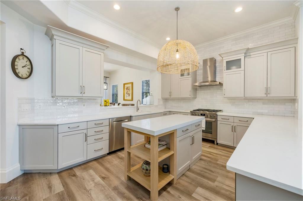 2870 Castillo Court, Unit 103 Naples, FL 34109 - Photo 1 of 34 a open kitchen with stainless steel appliances granite countertop a stove oven a sink dishwasher and white cabinets with wooden floor