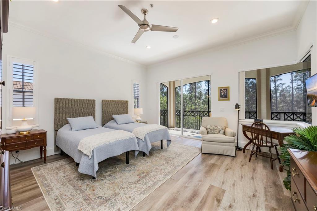 2870 Castillo Court, Unit 103 Naples, FL 34109 - Photo 11 of 34 a bedroom with a bed a large window and couch