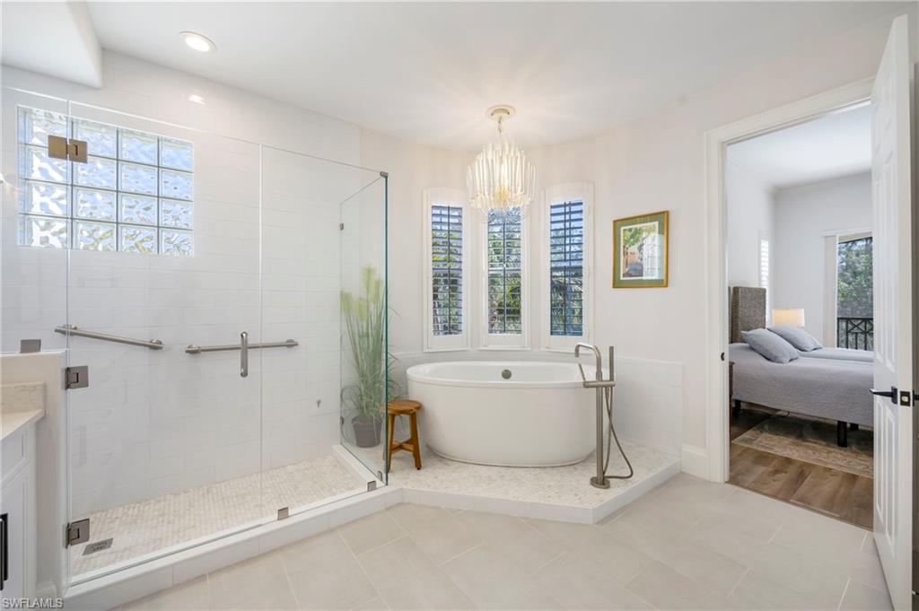 2870 Castillo Court, Unit 103 Naples, FL 34109 - Photo 14 of 34 a spacious bathroom with a tub shower and window
