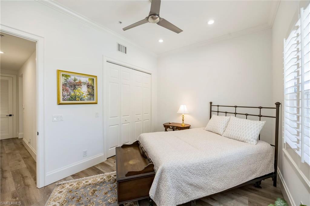 2870 Castillo Court, Unit 103 Naples, FL 34109 - Photo 17 of 34 a bedroom with a bed and wooden floor