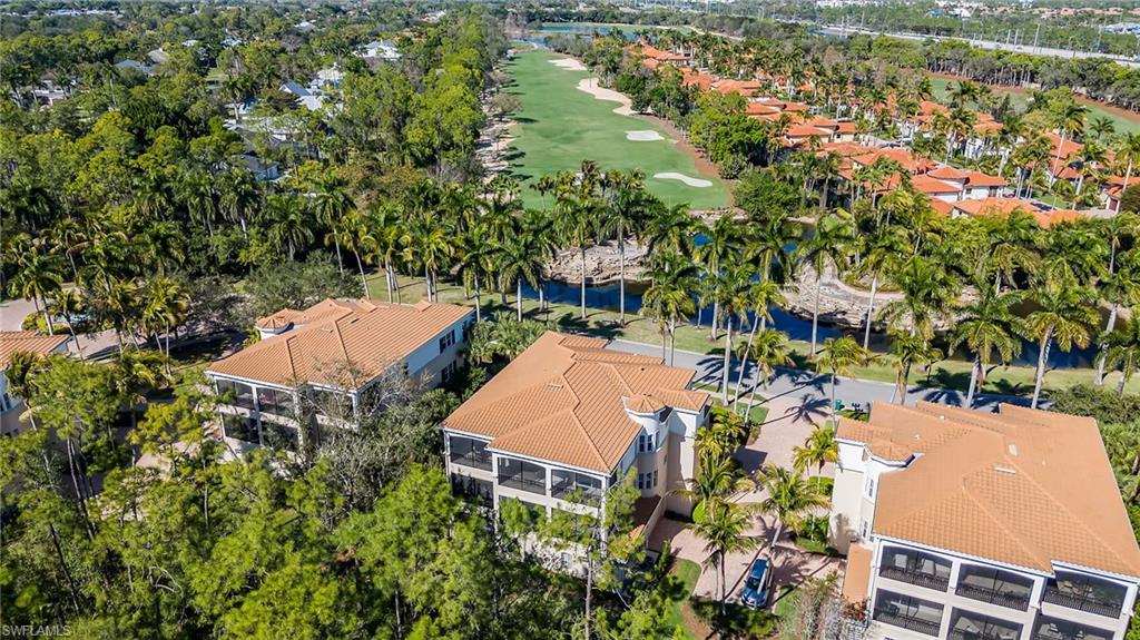 2870 Castillo Court, Unit 103 Naples, FL 34109 - Photo 26 of 34 an aerial view of a residential apartment building with a yard and parking spaces