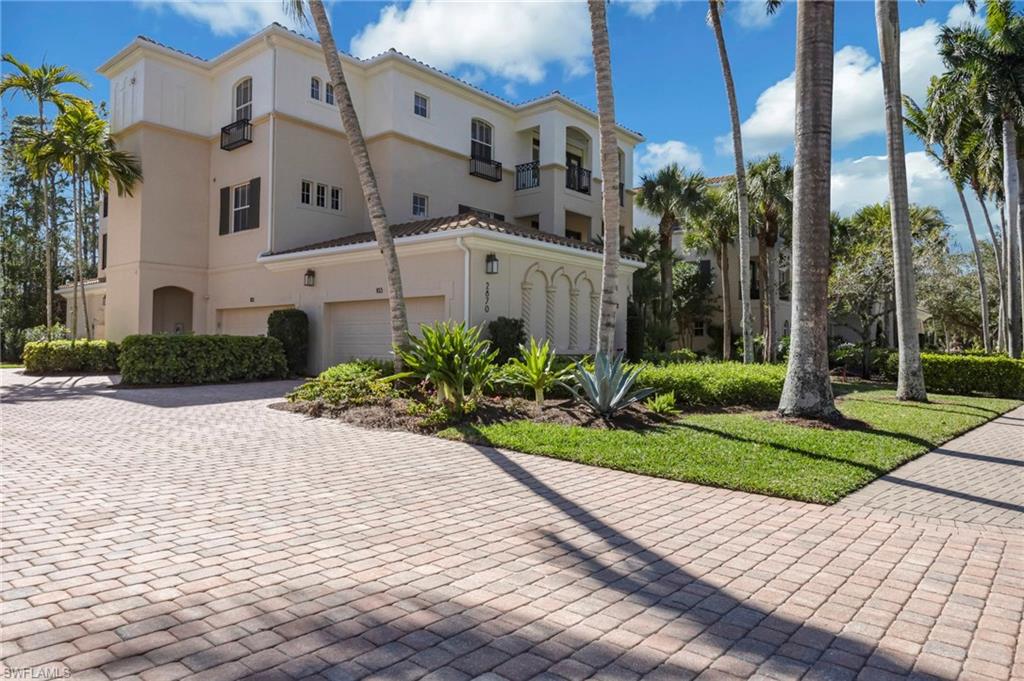 2870 Castillo Court, Unit 103 Naples, FL 34109 - Photo 29 of 34 a view of a white building next to a yard