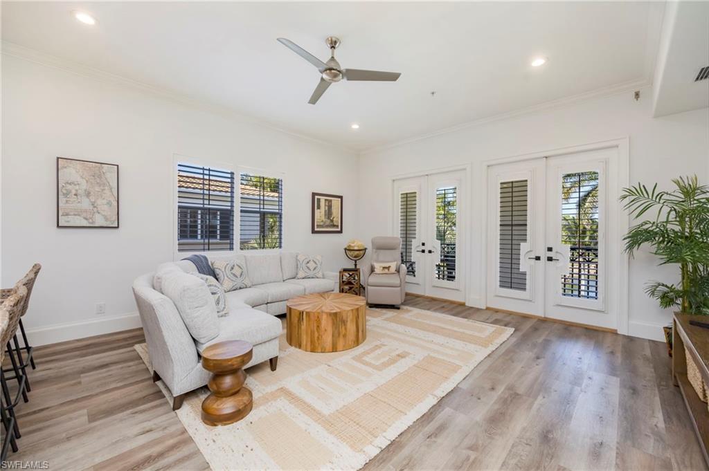 2870 Castillo Court, Unit 103 Naples, FL 34109 - Photo 6 of 34 a living room with furniture and wooden floor