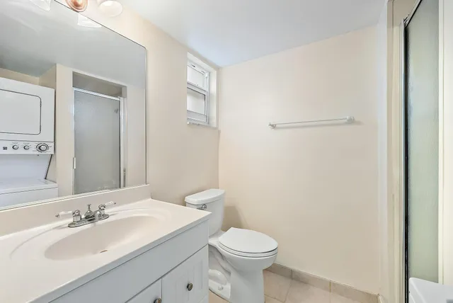 a bathroom with a granite countertop sink toilet and mirror