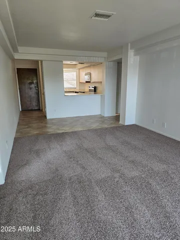 a view of a big room with wooden floor and windows