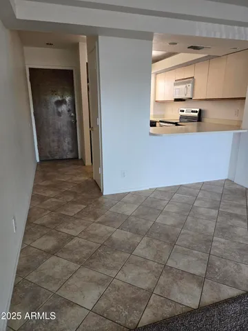 a view of a kitchen with kitchen island white cabinets and black appliances