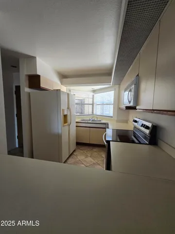 a kitchen with refrigerator and window