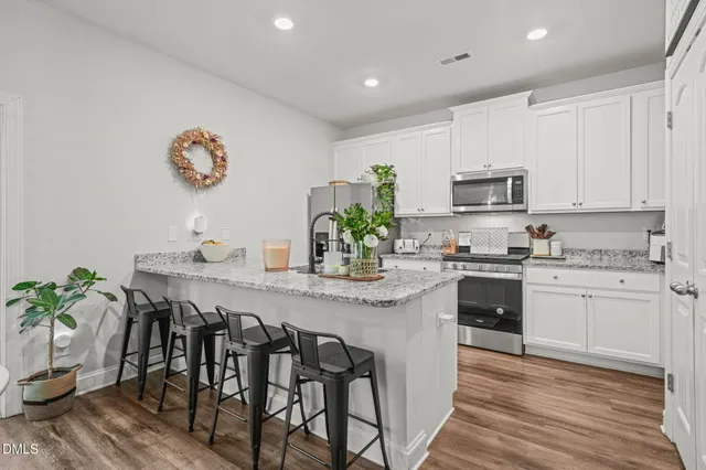 a kitchen with stainless steel appliances granite countertop a sink stove and cabinets
