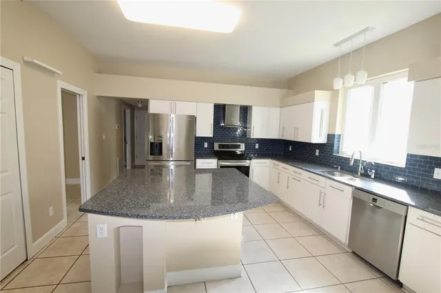 a kitchen with a sink a counter top space cabinets and stainless steel appliances