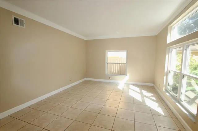 an empty room with a chandelier fan and a table