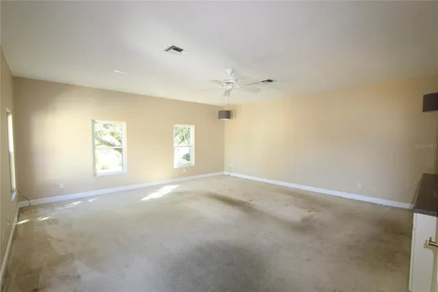 an empty room with a ceiling fan and a window