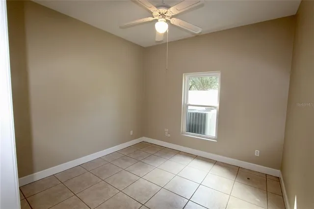 an empty room with closet and a chandelier fan