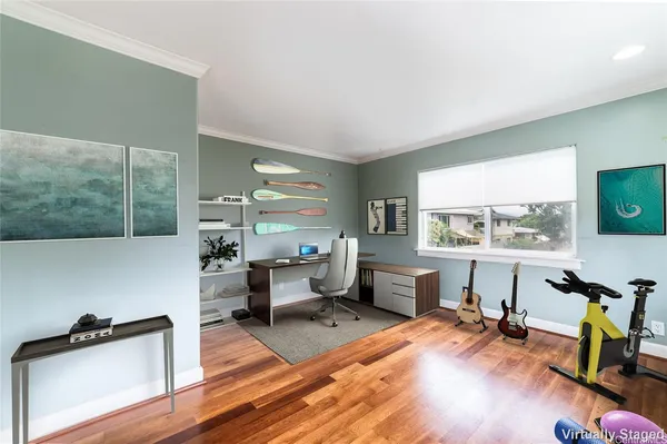 a living room with furniture a large window and wooden floor