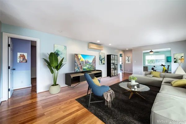 a living room with furniture potted plant a rug and a window