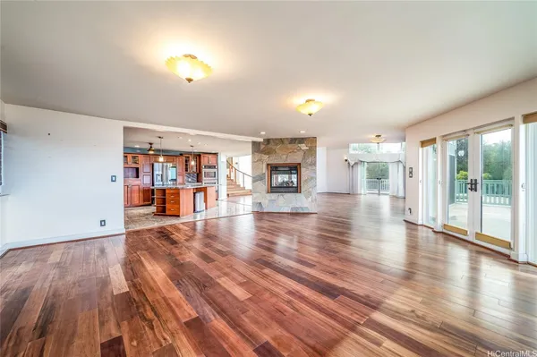 a view of a living room with wooden floor and book shelf