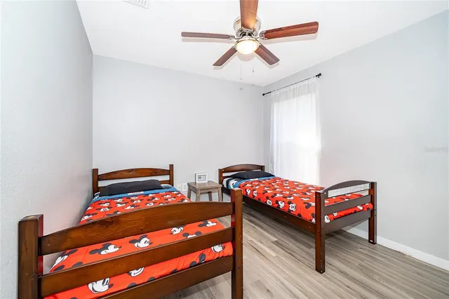 a bedroom with two beds and wooden floor