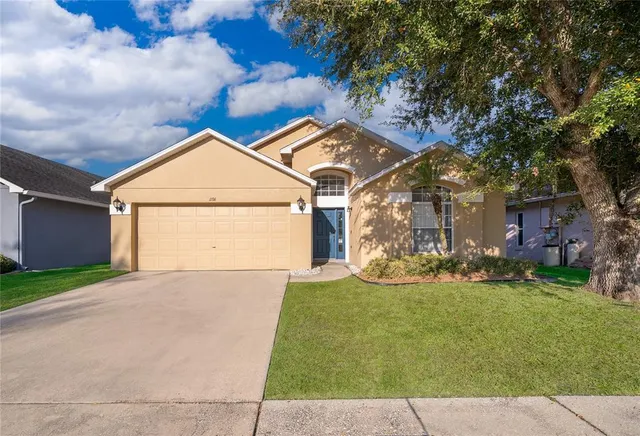 a view of a house with a yard and garage