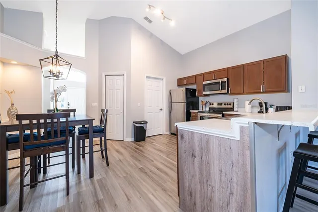 a kitchen with kitchen island granite countertop wooden floors and wooden cabinets