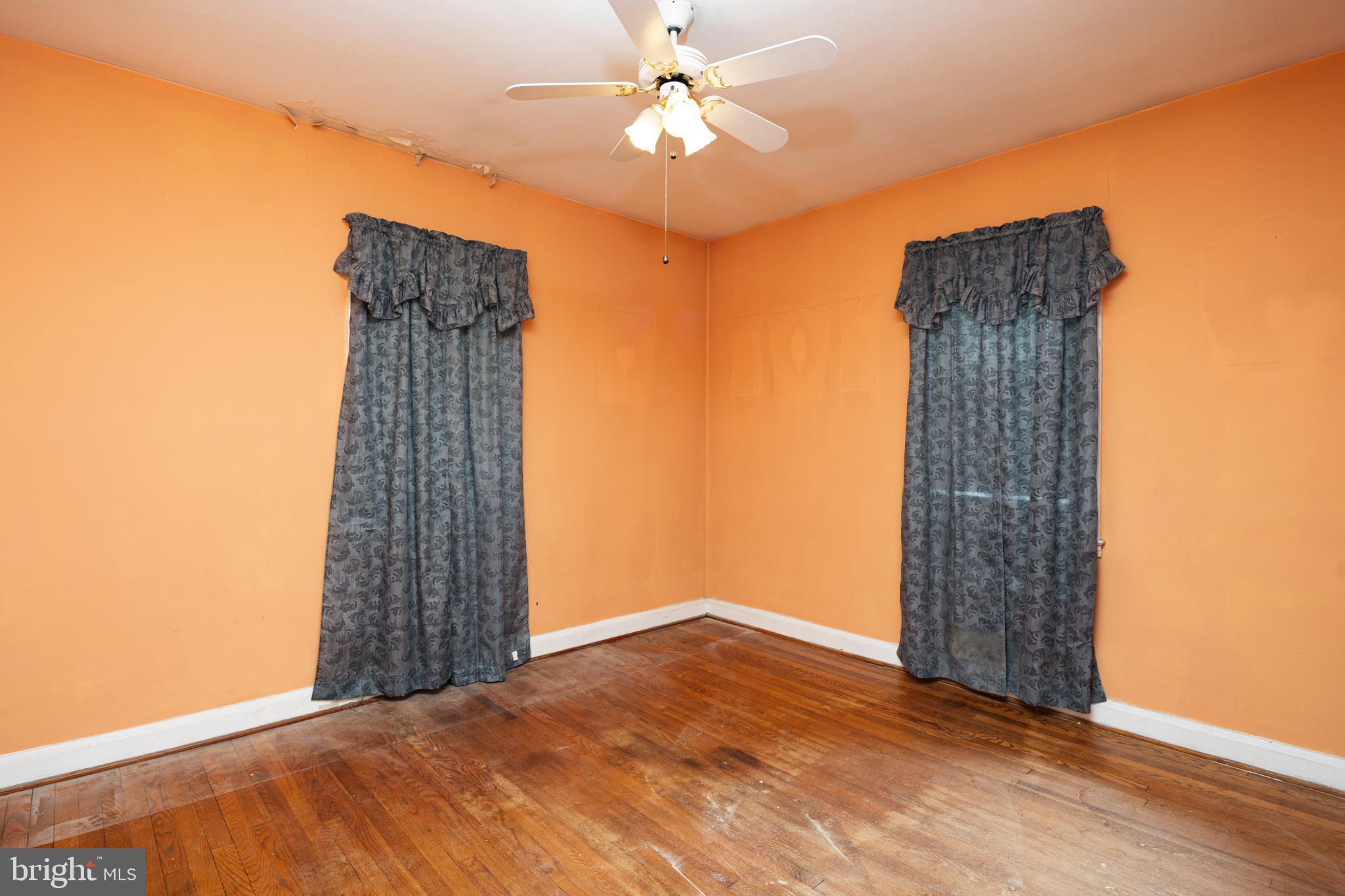 6627 Bushey Street Baltimore, MD 21224 - Photo 13 of 33 Bright orange walls with elegant drapes.
