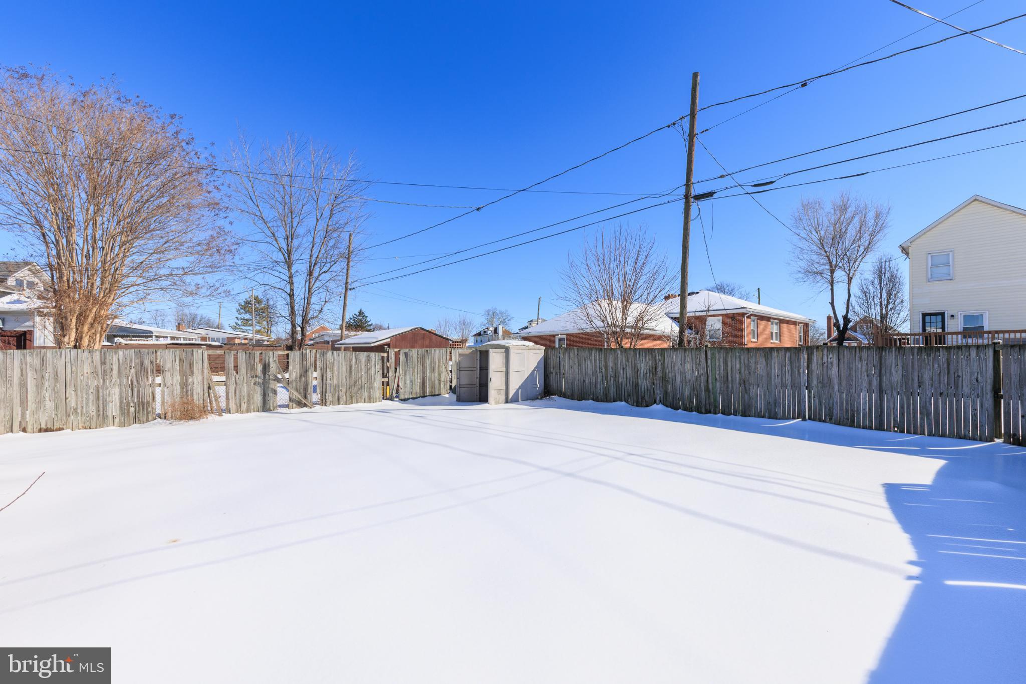 6627 Bushey Street Baltimore, MD 21224 - Photo 30 of 33 Snow-covered yard under a clear blue sky.