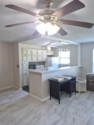 a kitchen with granite countertop a sink cabinets and wooden floor