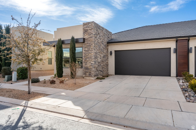4708 Martin Drive St. George, UT 84790 - Photo 3 of 28 Modern home featuring driveway, stucco siding, stone siding, a tiled roof, and an attached garage