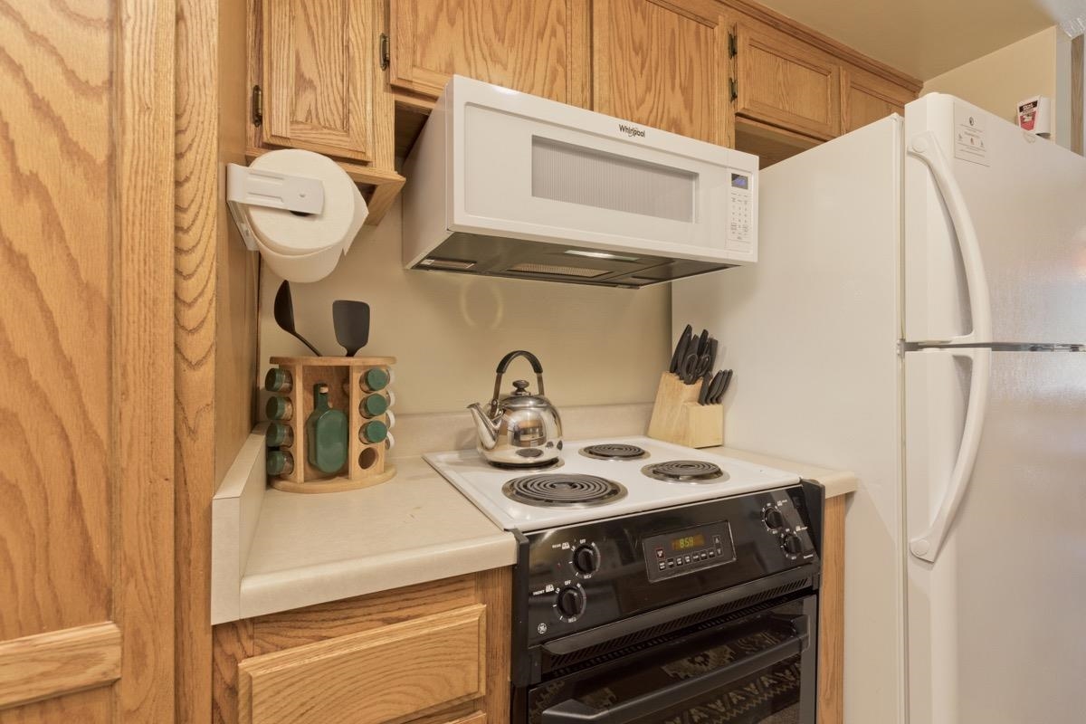 244 Lakeview Boulevard, Unit 149 Mammoth Lakes, CA 93546 - Photo 20 of 29 Kitchen featuring white appliances, light countertops, and light brown cabinets