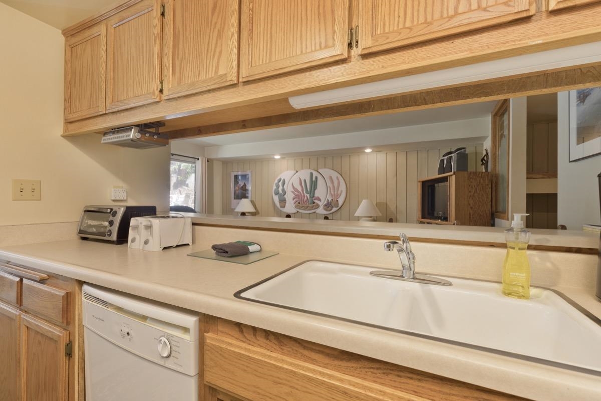 244 Lakeview Boulevard, Unit 149 Mammoth Lakes, CA 93546 - Photo 21 of 29 Kitchen featuring light countertops, white dishwasher, and light brown cabinets