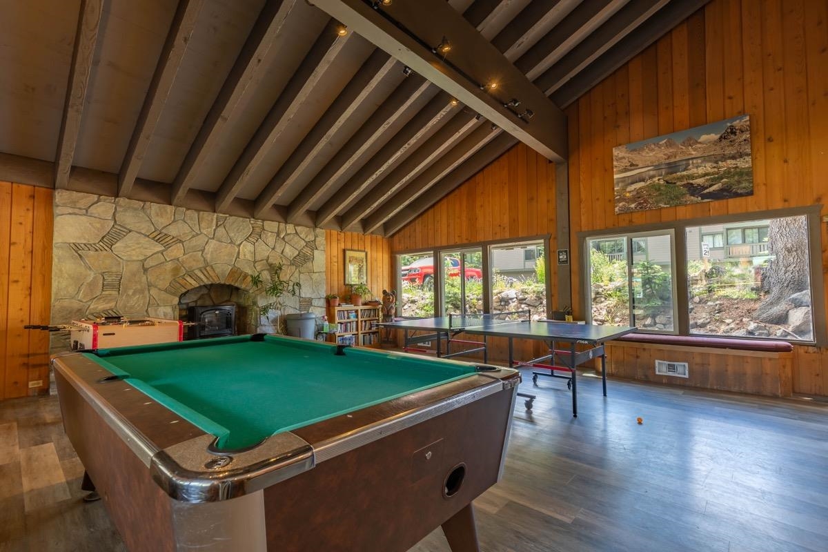 244 Lakeview Boulevard, Unit 149 Mammoth Lakes, CA 93546 - Photo 22 of 29 Playroom featuring wood walls, dark wood-style floors, billiards table, plenty of natural light, and a wood stove