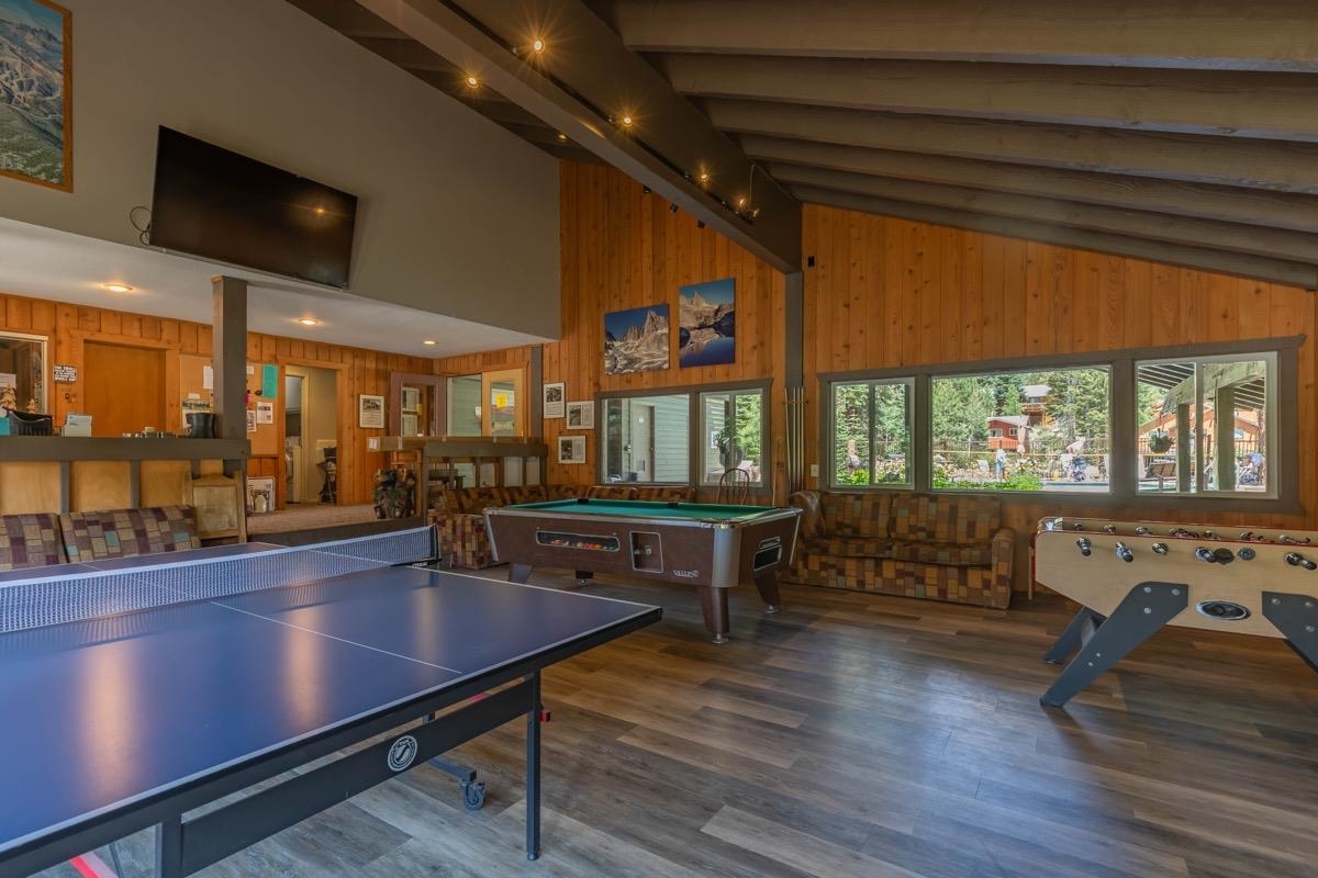 244 Lakeview Boulevard, Unit 149 Mammoth Lakes, CA 93546 - Photo 24 of 29 Rec room with beamed ceiling, wood finished floors, billiards table, high vaulted ceiling, and wooden walls