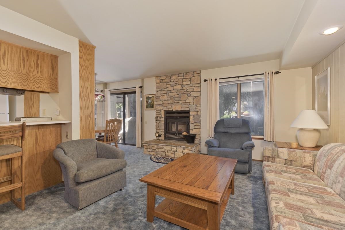 244 Lakeview Boulevard, Unit 149 Mammoth Lakes, CA 93546 - Photo 4 of 29 Living room with dark carpet and a fireplace