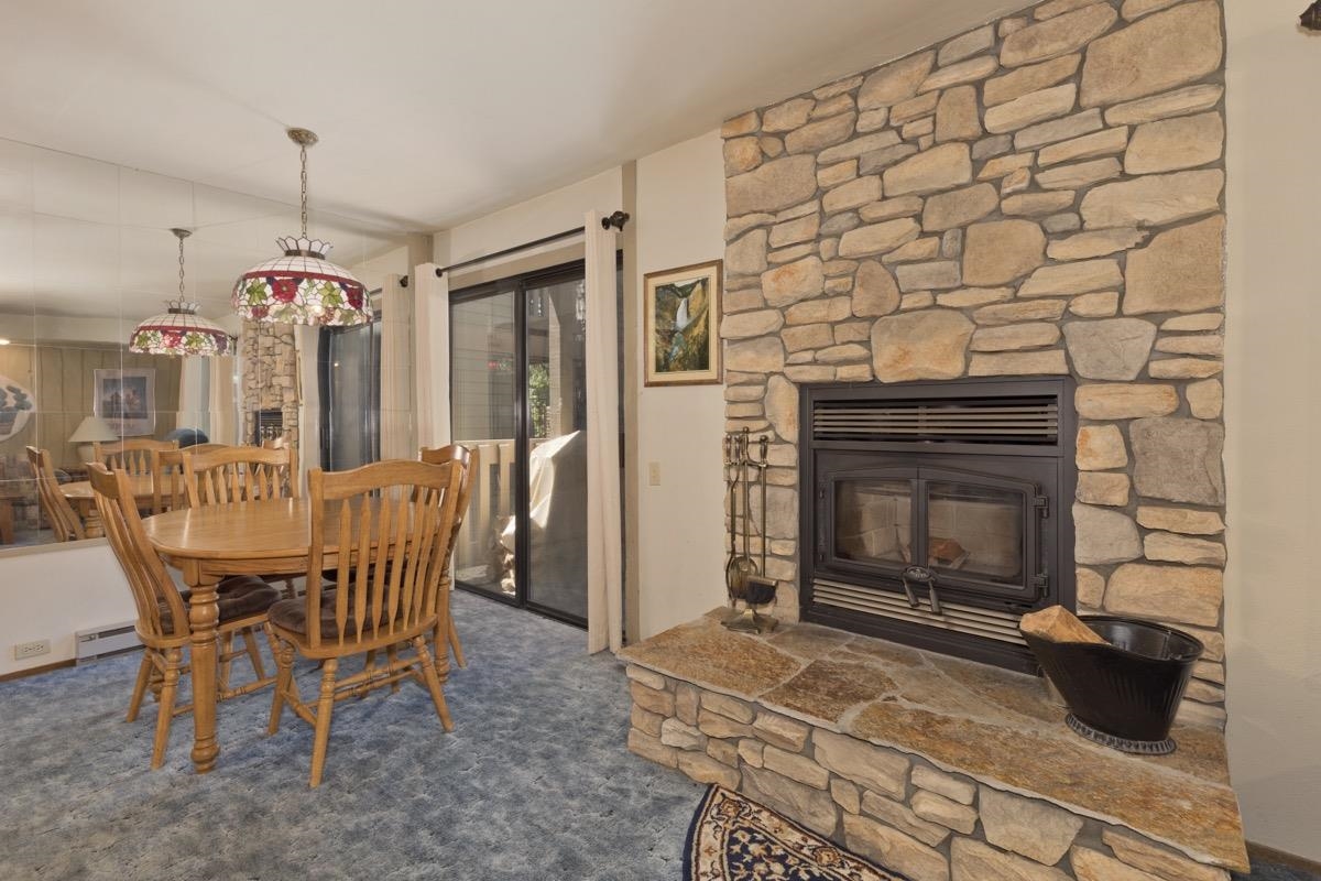 244 Lakeview Boulevard, Unit 149 Mammoth Lakes, CA 93546 - Photo 5 of 29 Dining area with a stone fireplace and carpet flooring