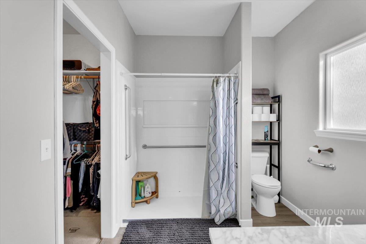 23919 Tyler Lane Middleton, ID 83644 - Photo 14 of 48 Bathroom with a spacious closet, a stall shower, and light wood-style flooring