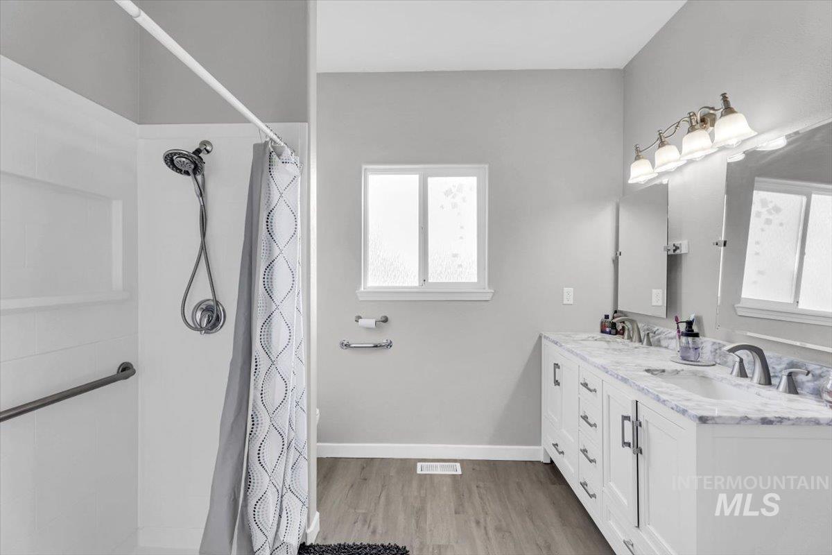 23919 Tyler Lane Middleton, ID 83644 - Photo 15 of 48 Bathroom with light wood finished floors, double vanity, and a shower with shower curtain