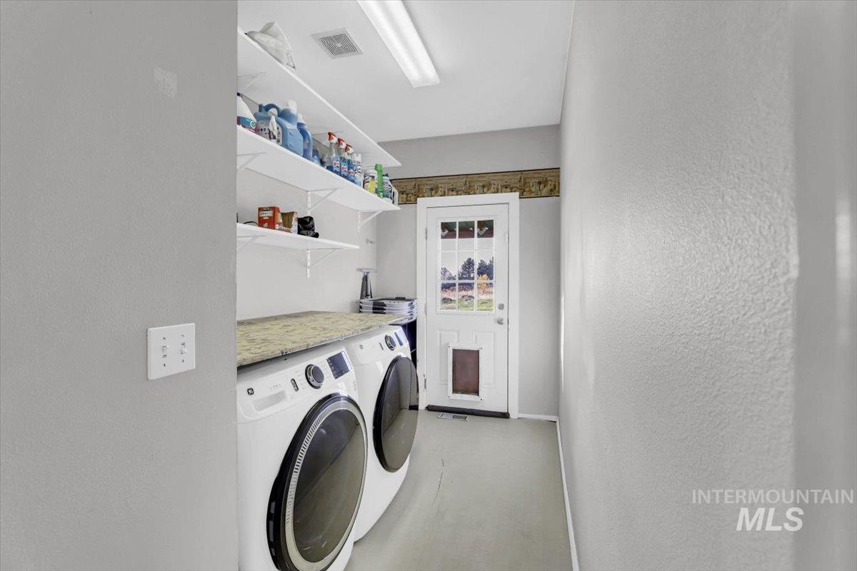 23919 Tyler Lane Middleton, ID 83644 - Photo 18 of 48 Laundry area featuring washing machine and clothes dryer and a textured wall