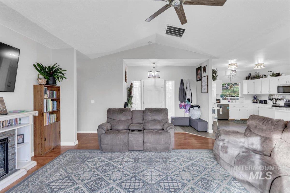 23919 Tyler Lane Middleton, ID 83644 - Photo 35 of 48 Living room featuring wood finished floors, lofted ceiling, ceiling fan, and a fireplace