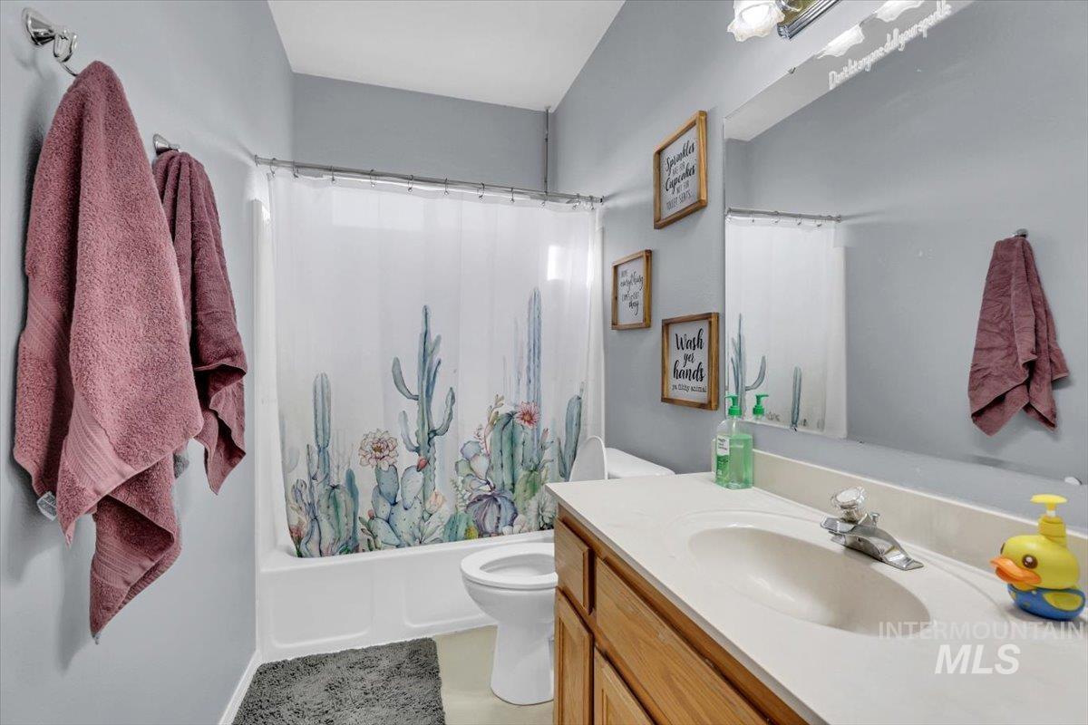 23919 Tyler Lane Middleton, ID 83644 - Photo 37 of 48 Full bath featuring shower / bathtub combination with curtain, vanity, and light tile patterned flooring