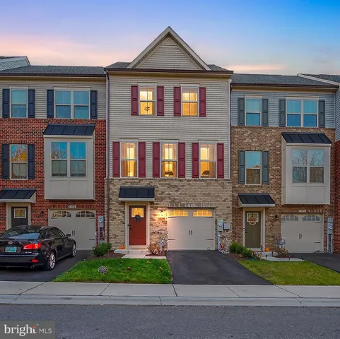a front view of a house with a yard and parking space