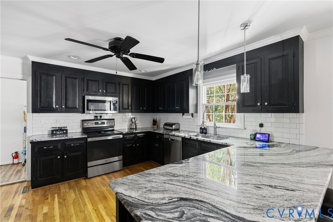 14321 Crossings Ridge Drive Midlothian, VA 23113 - Photo 13 of 43 a kitchen with stainless steel appliances granite countertop a sink stove microwave and cabinets