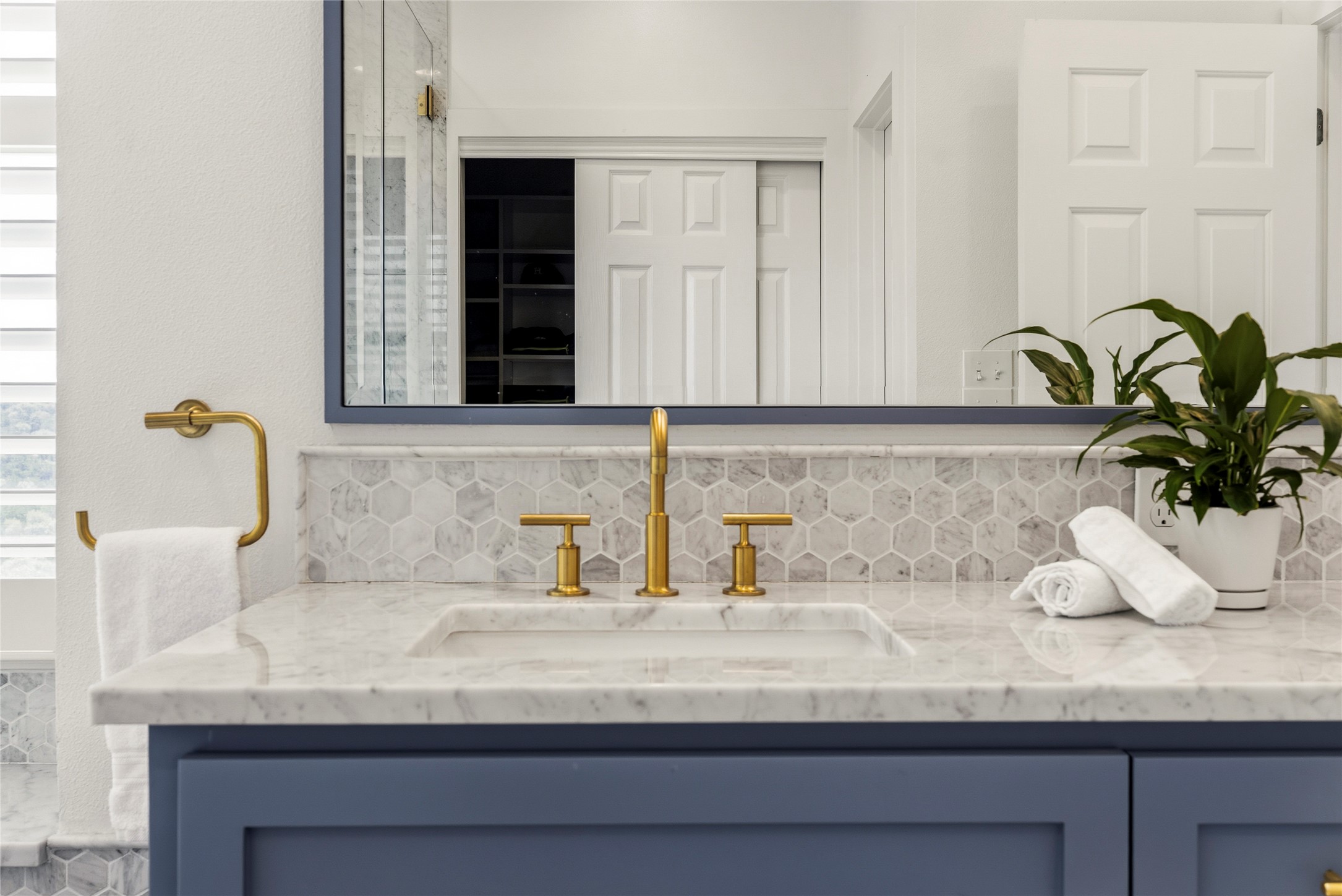 3107 Lookout Lane Austin, TX 78746 - Photo 26 of 39 Marble vanity with hexagon tile backsplash and sleek brass fixtures.