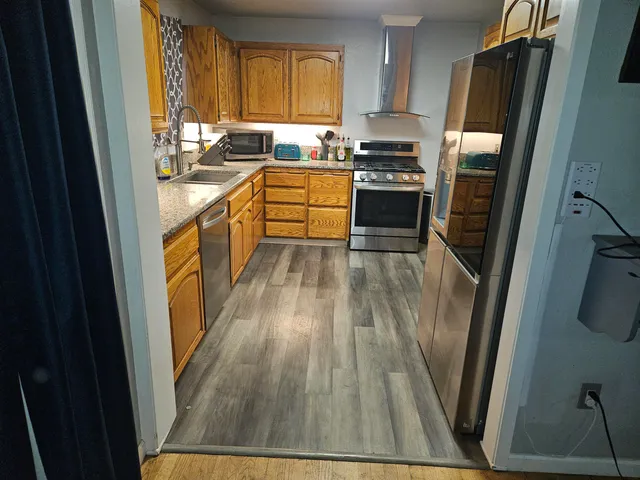 a kitchen with wooden floors and stainless steel appliances