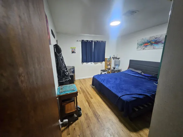 a bedroom with a bed and wooden floor