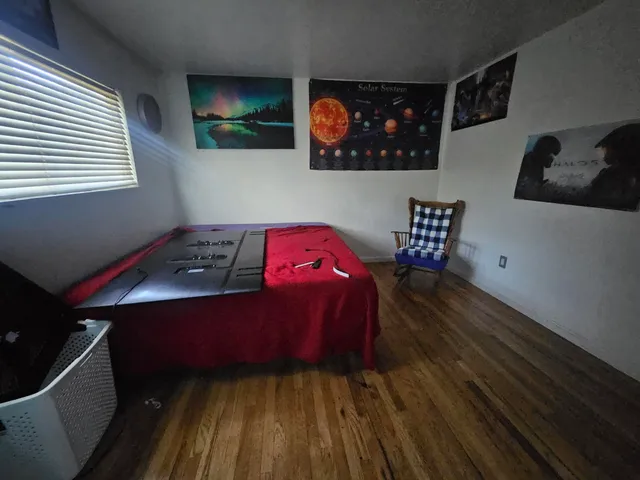 a bedroom with a bed and a lamp on dresser