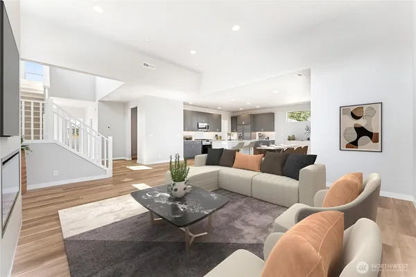 a living room with furniture kitchen view and a wooden floor