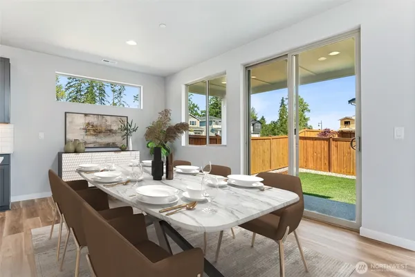 a dining room with furniture a large window and kitchen view