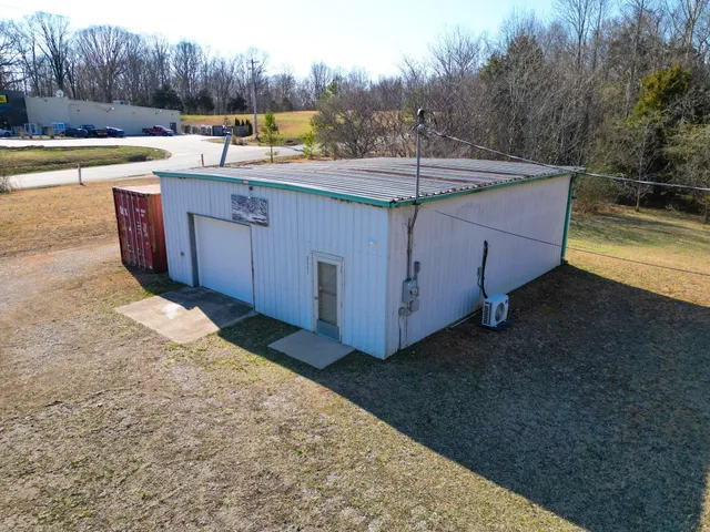 a backyard of a house with large trees and plants