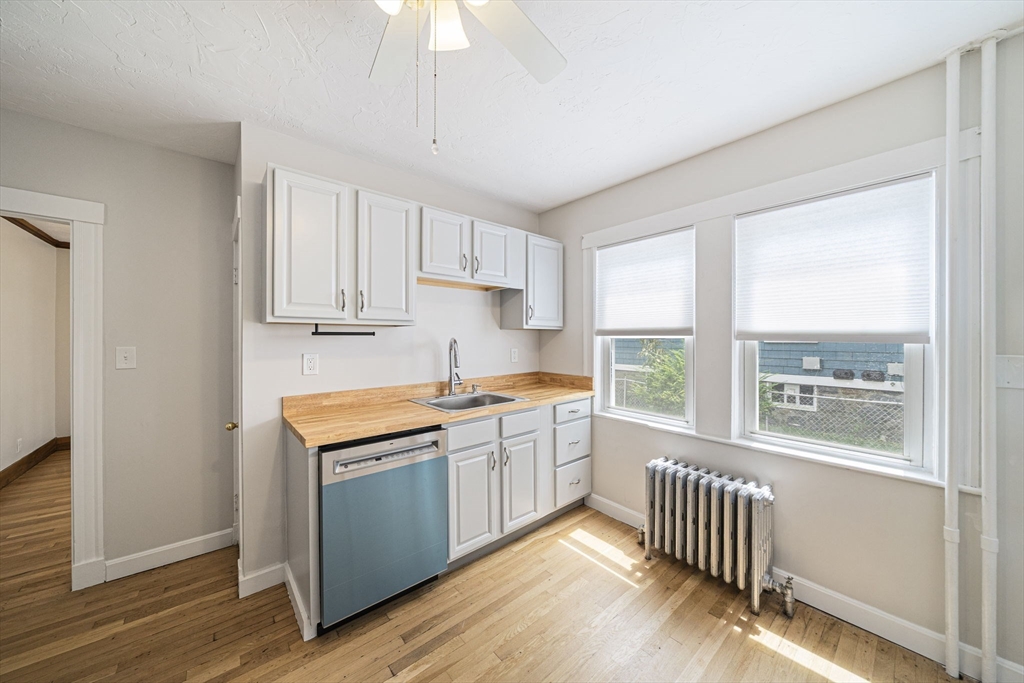 104 Greaton Road, Unit 1 Boston, MA 02132 - Photo 14 of 29 a kitchen with stainless steel appliances granite countertop a stove a sink and a window
